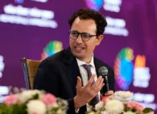 Dario Amodei, CEO Anthropic, berbicara sambil memegang mikrofon.