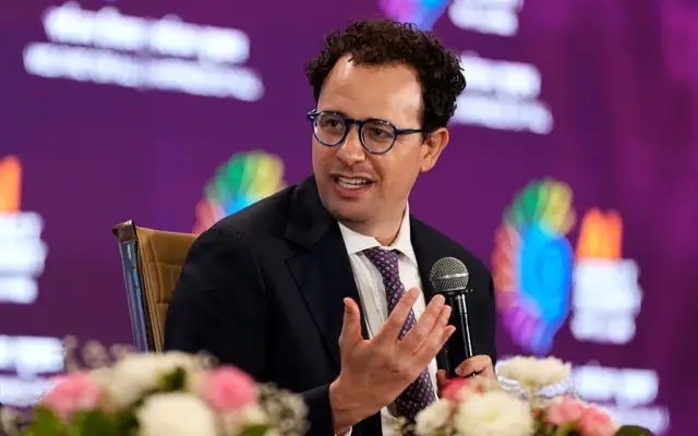 Dario Amodei, CEO Anthropic, berbicara sambil memegang mikrofon.