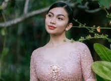 Ariel Tatum mengenakan Kebaya Rangkai Mawar pink muda dengan bros emas di Pura Mangkunegaran Solo