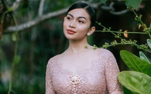 Ariel Tatum mengenakan Kebaya Rangkai Mawar pink muda dengan bros emas di Pura Mangkunegaran Solo