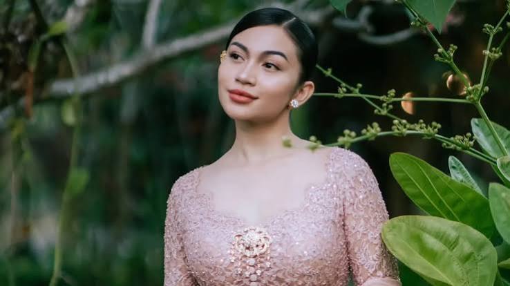 Ariel Tatum mengenakan Kebaya Rangkai Mawar pink muda dengan bros emas di Pura Mangkunegaran Solo